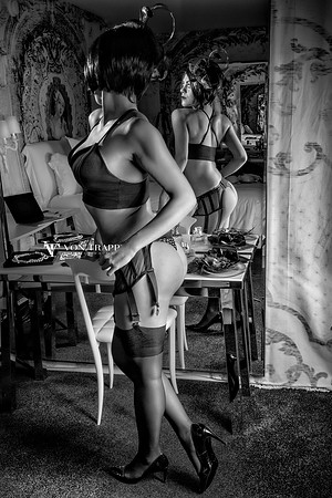 Boudoir photo of a woman wearing lingerie in front of a full length mirror.