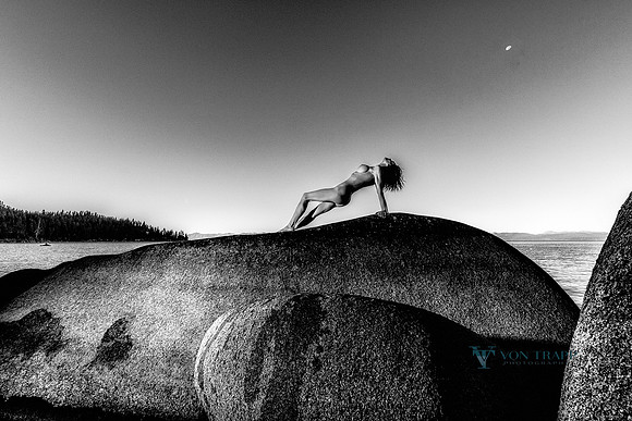 Fine art nude photograph of a woman posed. upon a huge bolder in Lake Tahoe.