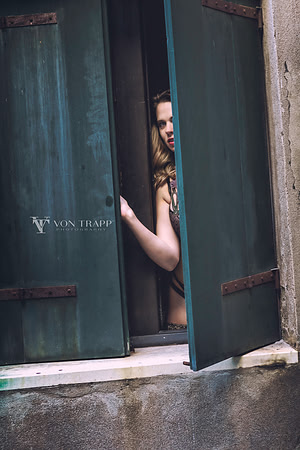 Sexy lingerie glamour photo of a woman at a window of a Venetian palazzo.