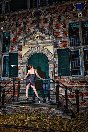 Sexy fashion photo of a woman in a revealing dress in public in Naarden Holland.