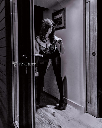 Sexy voyeur photo in B&W of a model dressing, as seen through a window.