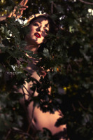 Beautiful nude woman peeking out from behind tree limbs, created in Naarden, Holland.