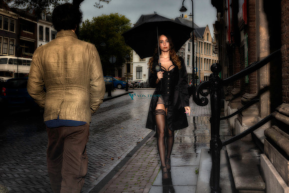 Fashion Glamour photograph taken in Gouda, Holland of a sexy Dutch woman walking through town holding an umbrella and dressed in sexy lingerie.