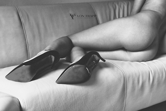 Art-fashion nude photo of a woman's legs in stilettoed heels laying on a sofa. San Antonio glamour Boudoir Fashion Photography.