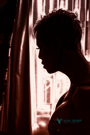 Sexy boudoir glamour portrait of a busty mature woman in profile, wearing a bra.