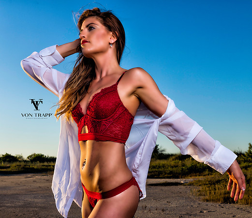 Fashion-glamour photo of a woman in sexy red lingerie and a sheer white shirt outdoors on a Texas beach.