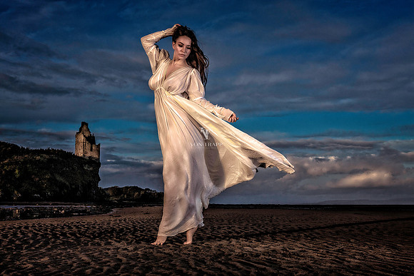 Fashion Glamour photo of a sexy woman in a shift, on a beach below Greenan Castle in Scotland.