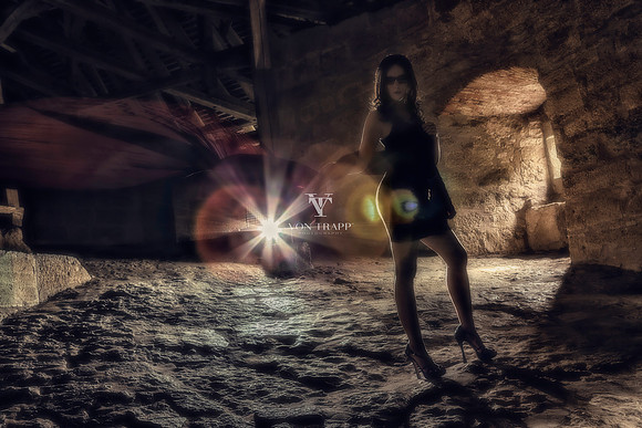 Edgy fashion photo of a leggy woman in a short dress, within the defensive wall of the medieval town of Rothenburg Germany.