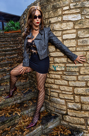 Photo of a seductive woman in a mini skirt, fashion tights, bustier, and cropped jacket. San Antonio Glamour Boudoir Photography.