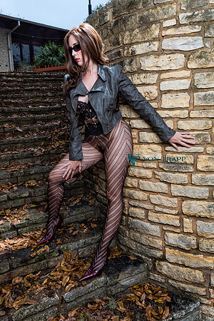 Erotic fashion-glamour photo of a semi-nude woman outdoors in public.