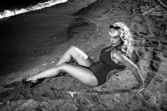 Retro inspired pinup glamour photo of a curvy blonde woman on the beach.