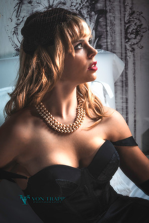 Old Hollywood style glamour photograph of a sexy blonde in a low-cut dress.