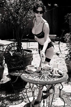 Fashion glamour photograph of a chesty woman in sexy lingerie and stockings, busting out of her bra outdoors.