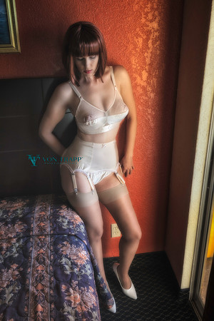 Boudoir pinup photograph of a sexy busty woman in a bullet bra and retro inspired garter belt and stockings.