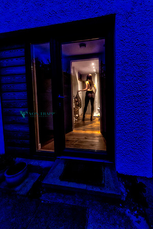 Sexy voyeur photo of a half nude woman seen through a window.