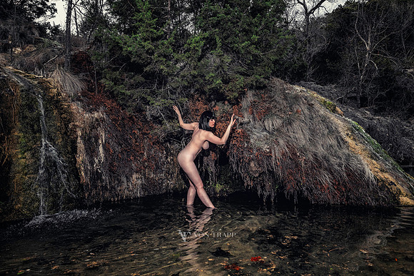 Art nude photo of a dark haired beauty posed in a river.
