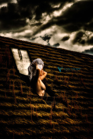 Art nude photo of a topless woman with a towel on her head, standing up through a stylite in Wales.