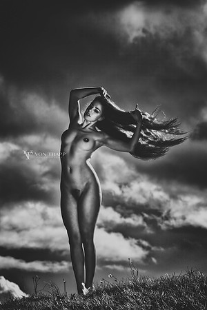 Art nude photograph of a long haired Dutch woman on a knoll in Holland.