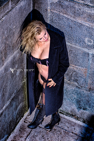 Hot busty model posed in lingerie and a long coat in public in Budapest.