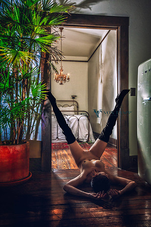 Erotic boudoir-glamour photo of a nude woman wearing thigh high come fuck me boots with her legs spread wide.