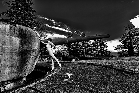 Art nude photograph of a woman posing outdoors alongside of a costal artillery gun in Ft  Columbia, Washington