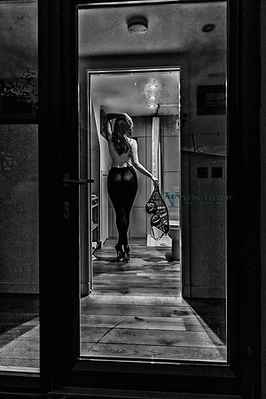 Erotic voyeur photo of a woman seen through a glass door, disrobing. Created in Scotland.