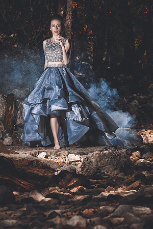 Fashion photo of a woman in a high low gown, running barefoot through a forest.