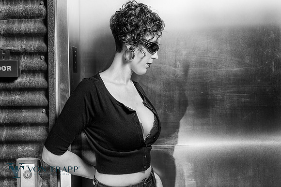 Edgy glamour portrait of a busty woman showing off her body.