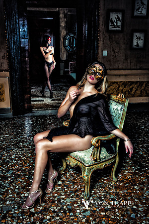 Fashion photo of two women wearing Venetian masks in a Venice palazzo.
