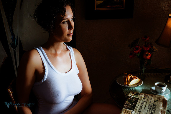 Boudoir photo of a braless woman in a sheer white tank top with great nipples.