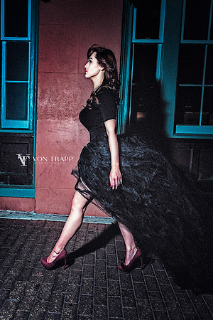 Photo of a very busty woman in profile, wearing a tulle skirt, tight top and stilettoes, walking in San Antonio.