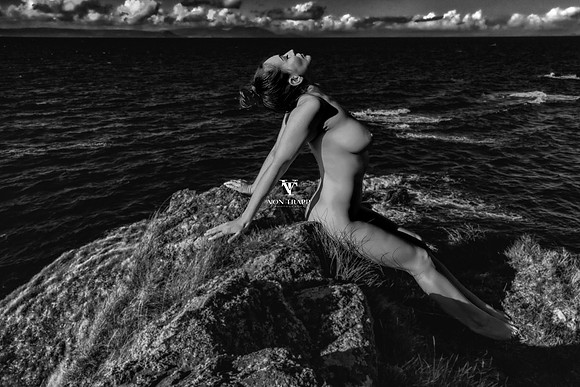 Art nude photo of a busty beauty on a knoll on the Scottish coast.