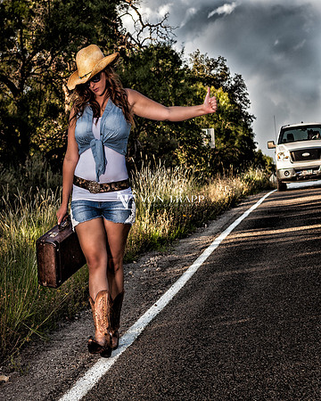 Texas Country Glamour Photo of a woman in short-shorts, cowgirl boots, hat, hitch hiking.