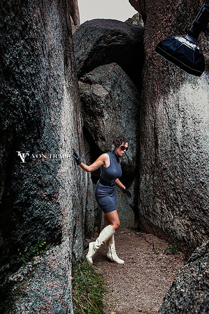 Behind the scenes fashion shoot photo of a woman in a huge rock crevice  in Texas.