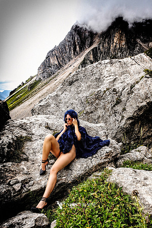 Photo of a nude woman wearing only a cape in public in the Italian Dolomites.