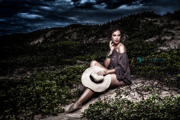 Fine art photo of a sexy woman with a hat, posed on a beach dune.