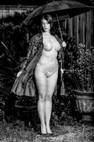 Hot woman in white lingerie posed in a rain holding an umbrella.